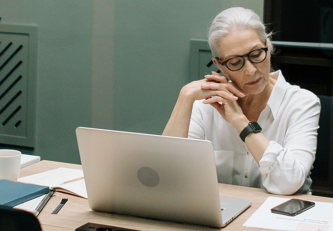 Experienced financial advisor reviewing investment data on a laptop.