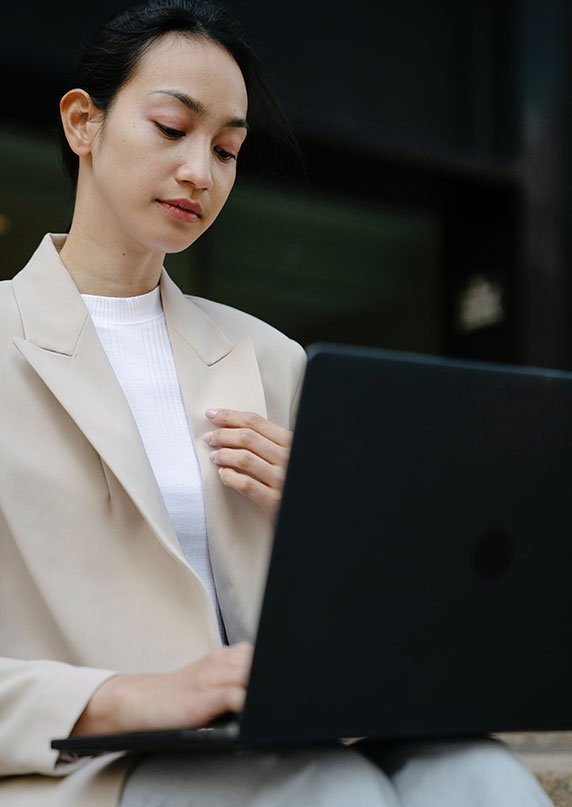 Focused investor managing her real estate portfolio on a laptop.