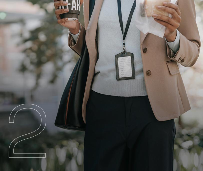 Real estate professional on a lunch break with ID badge and coffee.